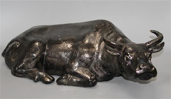 A Chinese black glazed pottery model of a seated water buffalo, length 56cm